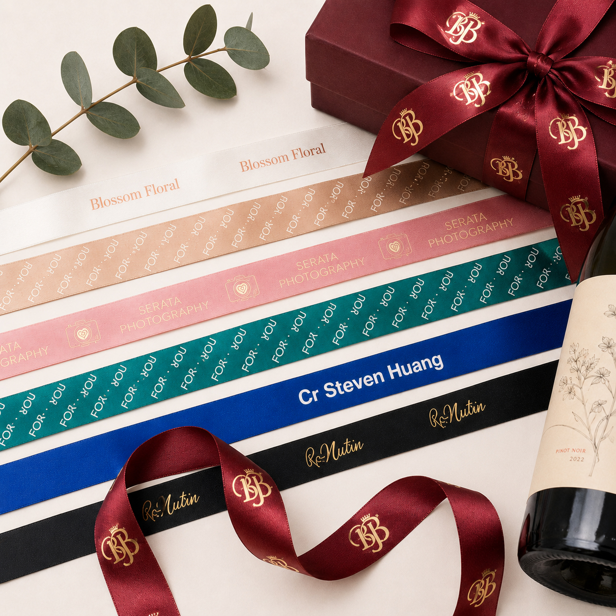 Metallic foil printed satin ribbon with premium gift packaging, featuring gold and silver foil logo printing on custom branded ribbon.