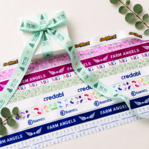 Full colour printed ribbon with vibrant custom logos and detailed artwork on premium satin ribbon for branded gift packaging.